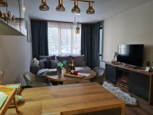 a living room with a table and a couch at Mountain Paradise in Aparthotel Borovets Gardens in Borovets