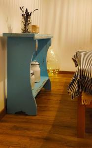 una habitación con una mesa azul con un aseo debajo en Egyszervolt Házikó, en Tiszafüred