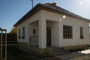 ein kleines weißes Haus mit einer Tür in der Unterkunft Egyszervolt Házikó in Tiszafüred