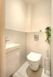 a bathroom with a white toilet and a sink at The Arches Watford Serviced Apartment in Watford