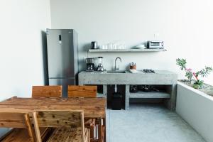 El Pescadero的住宿－Pacific Suite，厨房配有不锈钢冰箱和木桌