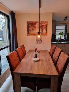 a dining room with a wooden table and chairs at Recreatiewoning Maas en Waal 72 in Ewijk