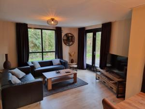 a living room with a couch and a tv at Recreatiewoning Maas en Waal 72 in Ewijk