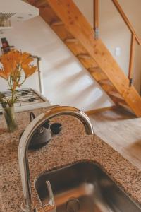 a kitchen counter with a sink and a staircase at Encanto Patagónico in El Bolsón