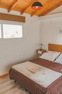 a bedroom with a large bed with a window at Encanto Patagónico in El Bolsón