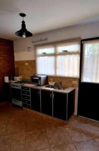 een keuken met een wastafel en een magnetron bij Duplex Boulevard A in Viedma