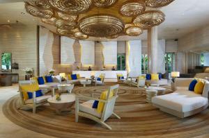 a lobby with couches and chairs in a building at Amari Phuket in Patong Beach