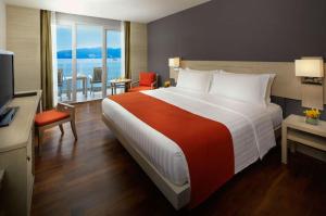 a hotel room with a large bed and a television at Amari Phuket in Patong Beach