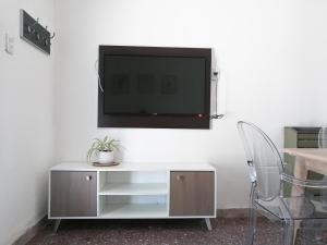 sala de estar con TV en una pared blanca en Departamento para 2 o 4 personas en Neuquén