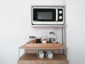 a microwave sitting on top of a shelf with cups at Departamento para 2 o 4 personas in Neuquén +10 photos