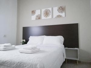 a bedroom with a white bed with towels on it at Departamento para 2 o 4 personas in Neuquén