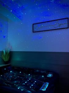 Bohème Spa Appartement privatif avec jacuzzi في أورليان: حوض استحمام في غرفة مع نجوم على الحائط