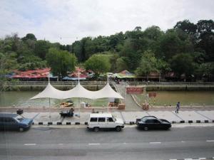 a white tent in a parking lot next to a river at The Brunei Hotel in Bandar Seri Begawan