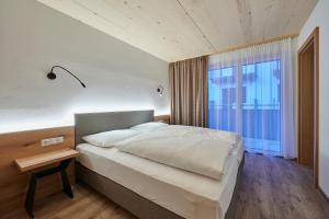 Un dormitorio con una cama grande y una ventana en Appartement Christina, en Saalbach Hinterglemm
