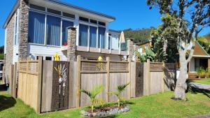 een houten hek voor een huis bij Margaritaville Hahei in Hahei