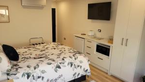 a small bedroom with a bed and a kitchen at Margaritaville Hahei in Hahei