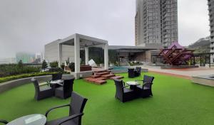 a rooftop patio with chairs and tables and grass at Studio Above The Cloud at Ion Element Genting in Genting Highlands