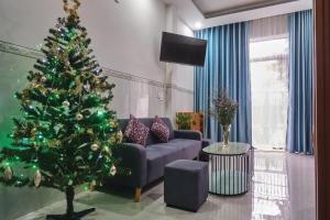 a living room with a christmas tree and a couch at Căn Hộ 3 PN Rin's House in Phan Thiet