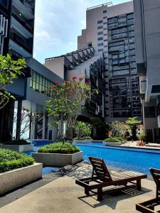 uma piscina num edifício com um banco e um edifício em BotakCuteHomestay@Imperio Residence em Malaca