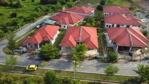 una vista aérea de una fila de casas con techos rojos en PATIN GUEST HOUSE @DESA TELOK IRA, TEMERLOH PAHANG, en Kampong Paya Kerinau