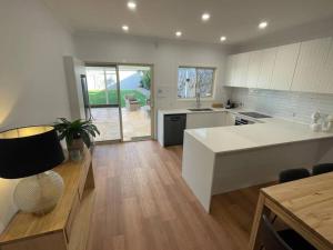 eine Küche mit einer weißen Arbeitsplatte und einem Tisch in der Unterkunft House on Argent Street in Broken Hill