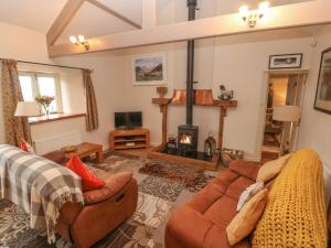 a living room with a couch and a fireplace at Old Tether Barn in Whitechurch