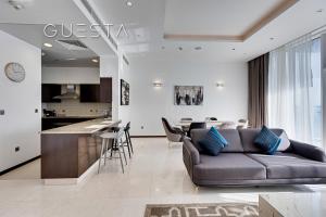 a living room with a couch and a kitchen at Tiara Residences, Free beach & pool access in Dubai