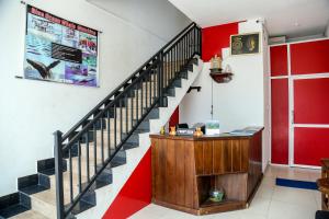 una escalera en una habitación con una pared roja y blanca en Isindu Sky Lodge, en Mirissa