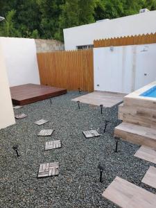 un patio con 2 mesas de picnic y una piscina en Maison chaleureuse avec Jacuzzi !, en Punta Cana