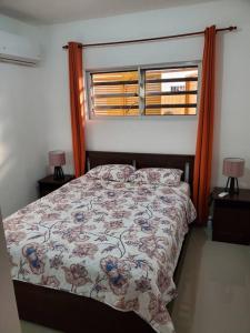 um quarto com uma cama e uma janela com 2 candeeiros em Maison chaleureuse avec Jacuzzi ! em Punta Cana