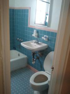 uma casa de banho azul com um WC e um lavatório em Collins Avenue Hostel em Miami Beach