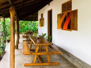 Habitación con mesa de madera y algunos bancos. en Forcus Cabanas, en Arugam Bay