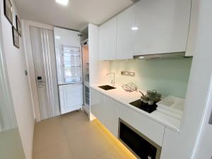 a small kitchen with white cabinets and a sink at Sands Condo Pattaya 13 in Pattaya South