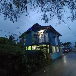 a blue house with a balcony at night at ANNI'S BEACH HOUSE in Lucena