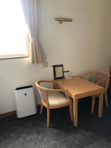 a table and two chairs and a table and a window at Hotel Plaisir Tachikawa in Tachikawa +10 photos