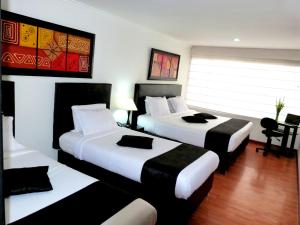 a hotel room with two beds and a window at Hotel Radel Bogotá in Bogotá