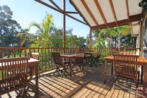 a wooden deck with tables and chairs on it at Oasis Inn Ulladulla - Welcoming Guests 18 Years and Older in Ulladulla