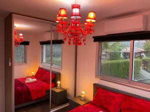 a bedroom with a red bed and a mirror at SOFROS VALLEY HILLS CHALET in Ayios Mamas