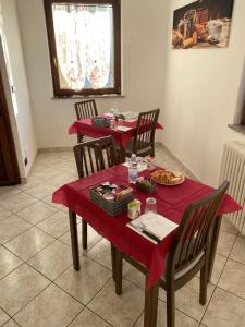 a dining room with two tables with red table cloth at La Ciuenda in Perosa Argentina