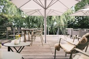 eine Terrasse mit Tischen, Stühlen und Sonnenschirmen in der Unterkunft Hotel Sturm Bio- & Wellnesshotel in der Rhön in Mellrichstadt