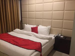 ein Bett mit einer roten Decke und weißen Kissen in der Unterkunft Shangrila Hotels and Resort in Murree