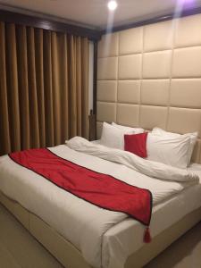 um quarto com uma cama grande e um cobertor vermelho em Shangrila Hotels and Resort em Murree