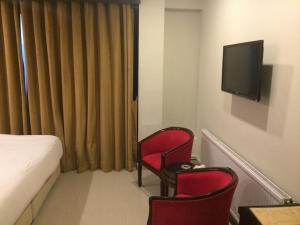 ein Hotelzimmer mit 2 roten Stühlen und einem TV in der Unterkunft Shangrila Hotels and Resort in Murree
