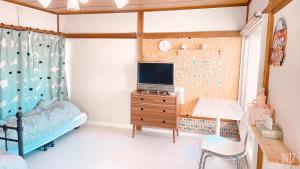 1 dormitorio con cama y vestidor con TV en 世田谷 大晶家 direct to Shinjuku for 13min 上北沢3分 近涉谷新宿 en Tokio