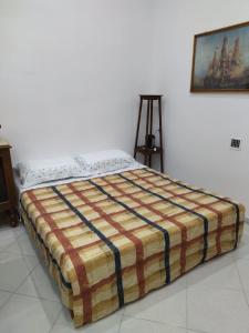 sypialnia z łóżkiem z paskowym kocem w obiekcie Nonno Ciccio Apartment w mieście Lizzano