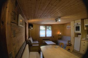 Il comprend un petit salon avec une table et une cuisine. dans l'établissement CHARMIEUX appartement en chalet typique, au Grand-Bornand