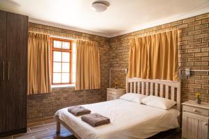 a bedroom with a white bed and a brick wall at De Hollandsche Molen in Hou Moed