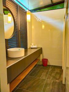 a bathroom with a tub and a sink with a mirror at Boulder Valley in Batu Ferringhi