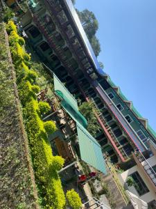 un edificio con plantas verdes a su lado en Stupa Guest House, en Bīr