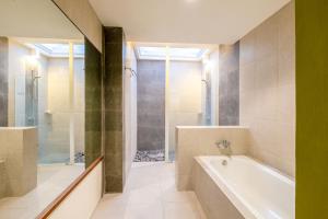 a bathroom with a tub and a shower at mascot hotel senggigi in Senggigi +38 photos